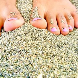 Low section of woman legs on sand