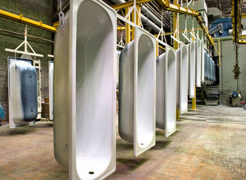 White bathtubs hanging on production line at upper iset plant