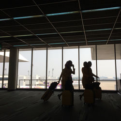 Silhouette people sitting on floor in building