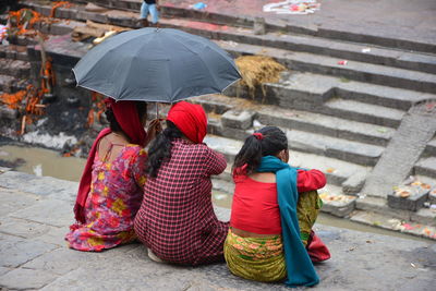 Rear view of women sitting outside the temple