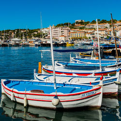 Boats moored in sea against clear blue sky