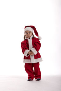 Full length of smiling girl standing against white background