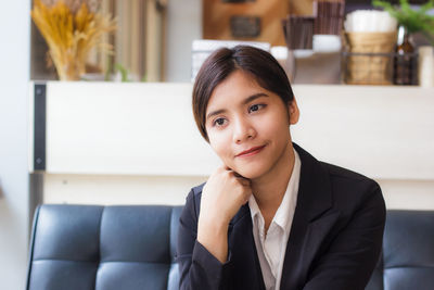 Businesswoman looking away while sitting on couch