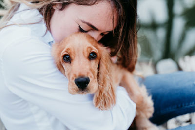 Portrait of cute dog relaxing on man