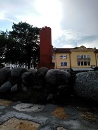 View of buildings and rocks against sky