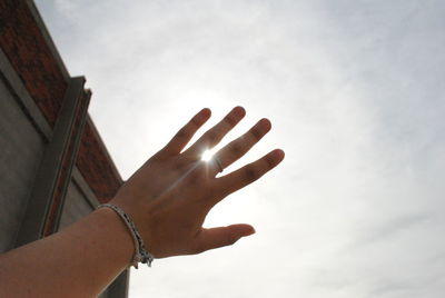 Low angle view of hand against sky