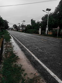 View of railroad tracks by road against sky