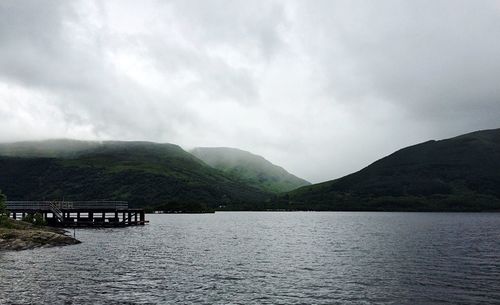 Scenic view of bridge over mountains against sky