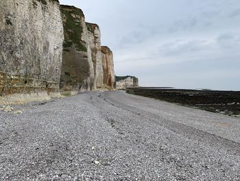 Surface level of road amidst rocks against sky