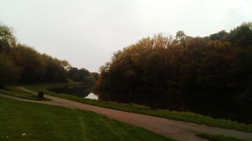 Road amidst trees against sky during autumn