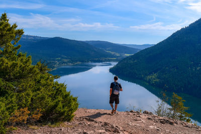 Rear view of man looking at mountains against sky