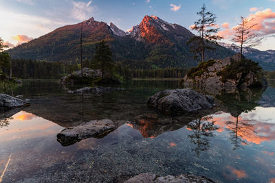 Scenic view of lake and mountains against sky during sunset