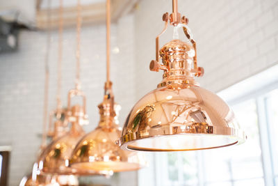 Low angle view of illuminated pendant light hanging from ceiling