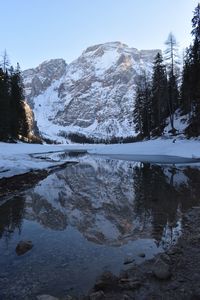 Scenic view of lake by snowcapped mountains against sky