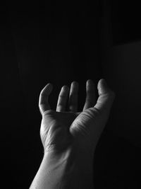 Close-up of human hand against black background