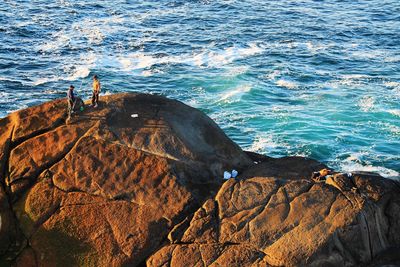 High angle view of man standing on rock at beach