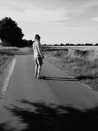 Full length of man skateboarding on road against sky