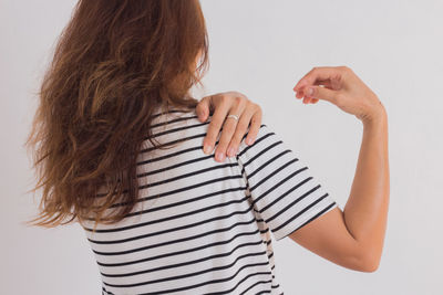 Rear view of woman standing against white background