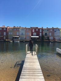 Rear view of man standing on jetty