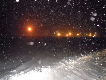 Scenic view of snow against sky at night