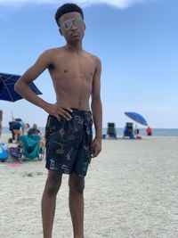 Portrait of shirtless teenage boy standing at beach