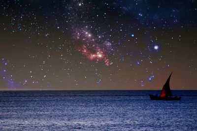 Boat on sea against stars in sky