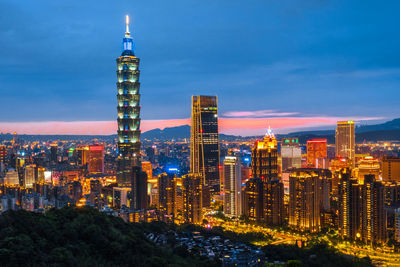 Illuminated buildings against sky at night