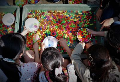 Directly above shot of girls with colorful balls crate