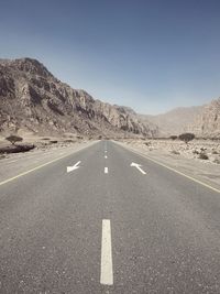 Road leading towards mountains against sky