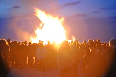 Crowd at music concert against sky at night