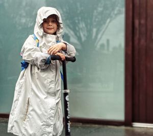 Portrait of cute girl standing on push scooter  outdoors