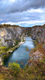 High angle view of lake amidst rocks against sky