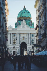 People against hofburg on street in city