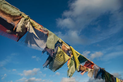 Low angle view of prayer flags hanging against sky