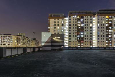 Illuminated buildings against sky at night