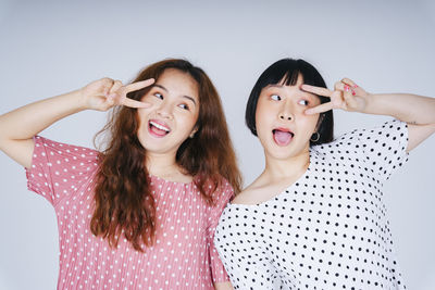 Portrait of lesbian couple against gray background