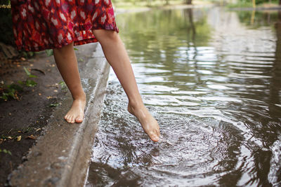 Low section of woman standing in lake