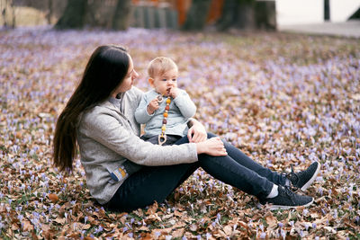 Mother and son sitting on autumn leaves