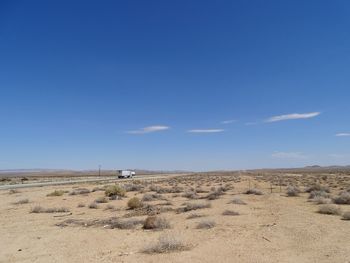 Scenic view of desert against clear blue sky