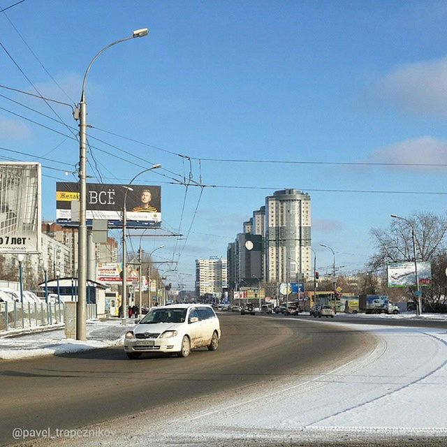 transportation, building exterior, car, street, architecture, built structure, land vehicle, city, mode of transport, road, power line, road sign, city life, blue, city street, street light, electricity pylon, clear sky, sky, traffic