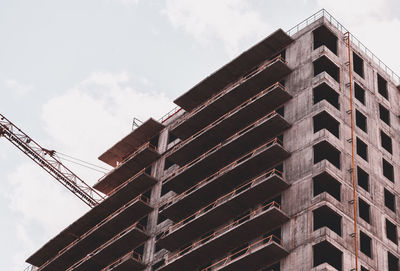 Skyscraper and building crane at a construction site.