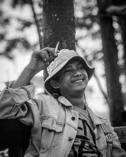 Portrait of smiling man against tree trunk