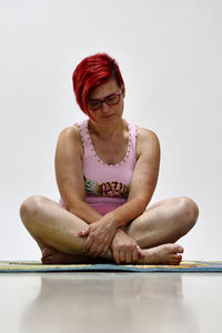 Midsection of woman sitting against gray background
