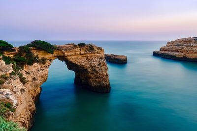 Rock formations by sea against sky