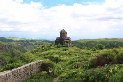 Built structure on landscape against sky