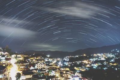 Illuminated cityscape against sky at night