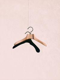Coathanger hanging against white wall