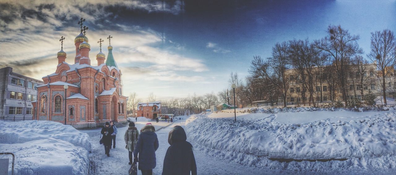 winter, snow, cold temperature, building exterior, architecture, built structure, season, weather, sky, lifestyles, men, bare tree, frozen, leisure activity, city, tree, covering, cloud - sky, person