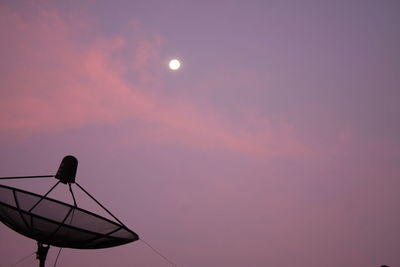 Low angle view of communications tower against sky at sunset