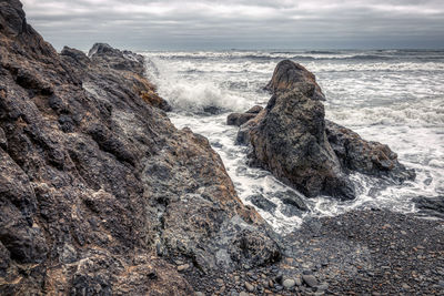 Scenic view of rocks in sea against sky